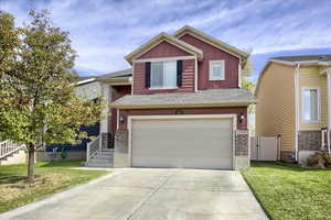 View of front of house featuring a garage and a front lawn