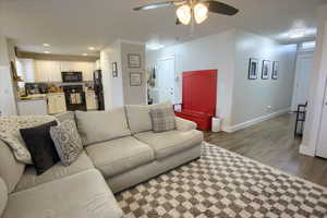 Living room with ceiling fan, sink, and hardwood / wood-style floors