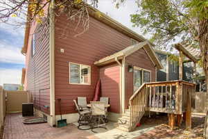 Rear view of house featuring a patio, a deck, and central AC unit