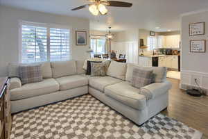 Living room with ceiling fan, sink, and light wood-type flooring