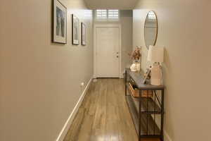 Hall featuring light  laminate wood-type flooring