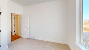 Carpeted spare room with a healthy amount of sunlight