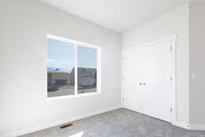 Unfurnished bedroom featuring carpet and a closet