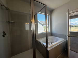 Bathroom with a textured ceiling, plenty of natural light, and plus walk in shower