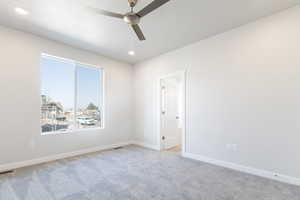 Empty room featuring light carpet and ceiling fan