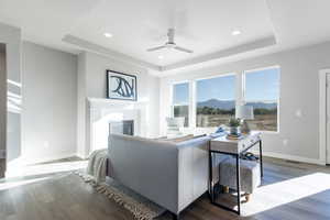 Living room featuring a mountain view, wood-type flooring, and ceiling fan