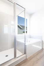 Bathroom featuring hardwood / wood-style floors and independent shower and bath