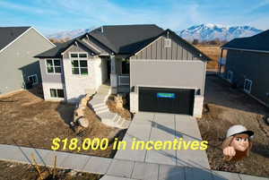 View of front of house with a mountain view and a garage