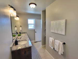 Bathroom with vanity, a textured ceiling, and tile patterned floors