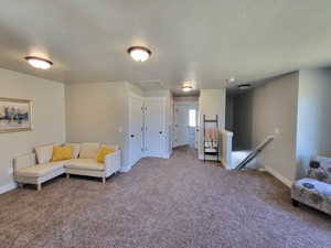 Living area with carpet flooring and a textured ceiling