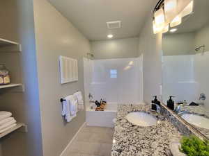 Bathroom featuring vanity, tile patterned floors, and shower / tub combination