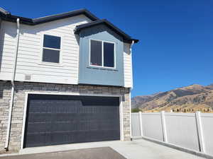 View of side of home with a garage and a mountain view