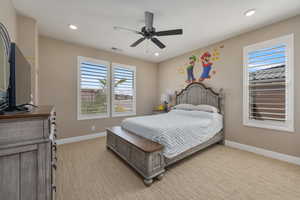 Carpeted bedroom featuring ceiling fan