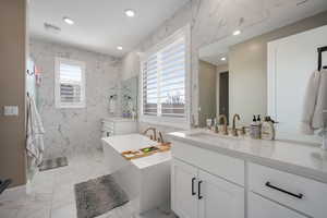 Bathroom with vanity, independent shower and bath, and plenty of natural light