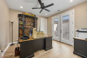 Office with french doors, light hardwood / wood-style floors, and ceiling fan