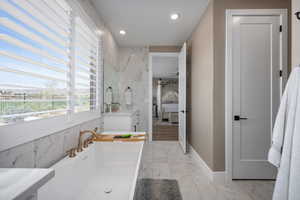 Bathroom featuring vanity, tile walls, a bath, and ceiling fan