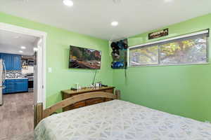 Bedroom with light hardwood / wood-style floors and stainless steel refrigerator