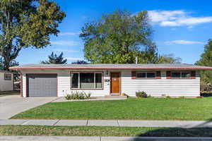 Ranch-style house with a front yard and a garage