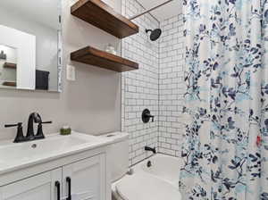 Full bathroom with vanity, toilet, and shower / bathtub combination with curtain