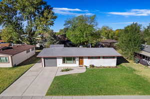 Ranch-style house with a garage and a front lawn