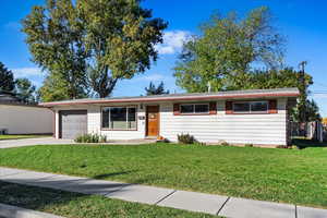 Single story home with a front yard and a garage