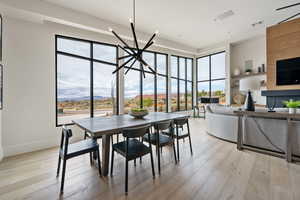 Dining area with an inviting chandelier, light hardwood / wood-style flooring, and plenty of natural light