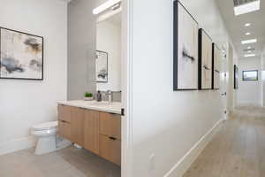 Bathroom featuring vanity, toilet, and wood-type flooring