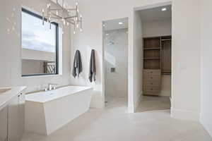 Bathroom featuring vanity, an inviting chandelier, separate shower and tub, and tile patterned flooring