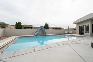 View of swimming pool featuring a patio and a water slide