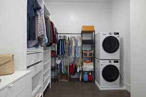 Clothes washing area with stacked washer / dryer and dark hardwood / wood-style floors