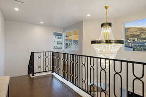 Corridor featuring a chandelier and dark wood-type flooring