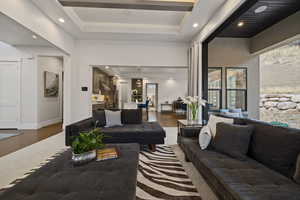 Living room with a tray ceiling and dark hardwood / wood-style flooring