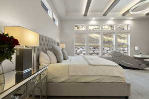 Bedroom with a towering ceiling, carpet flooring, beamed ceiling, and multiple windows