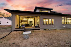 Back house at dusk featuring outdoor lounge area