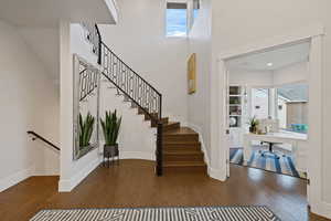 Staircase with hardwood / wood-style flooring and a healthy amount of sunlight