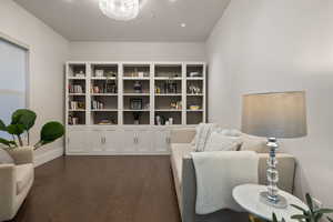 Living area featuring a notable chandelier and dark hardwood / wood-style flooring