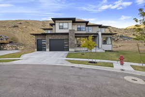 View of front of house with a front yard, a garage, and a mountain view