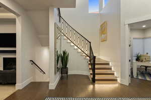 Staircase featuring wood-type flooring and a high ceiling