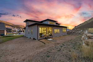 Back house at dusk with a patio and a mountain view