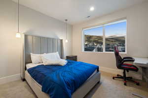 Bedroom featuring light carpet and a mountain view