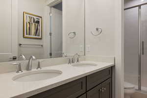 Bathroom featuring toilet, walk in shower, and vanity