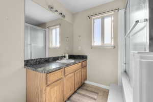 Bathroom with vanity, a healthy amount of sunlight, and walk in shower