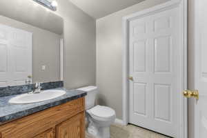 Bathroom featuring vanity, a textured ceiling, and toilet