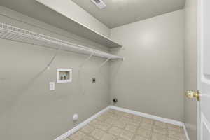 Laundry area featuring hookup for an electric dryer, a textured ceiling, gas dryer hookup, and washer hookup