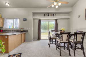 Carpeted dining area featuring sink and ceiling fan