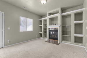 Unfurnished living room with carpet and a textured ceiling