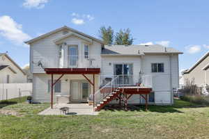 Back of property with an outdoor fire pit, a patio area, a lawn, and a balcony