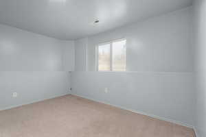 Unfurnished room featuring light colored carpet