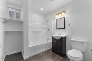 Full bathroom featuring vanity, toilet, hardwood / wood-style flooring, and shower / tub combination