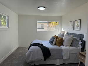 Bedroom featuring dark colored carpet and a textured ceiling